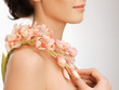 woman's shoulder and hands holding orchid flower