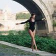 Young beautiful ballerina dancing under Castel Santangelo bridge