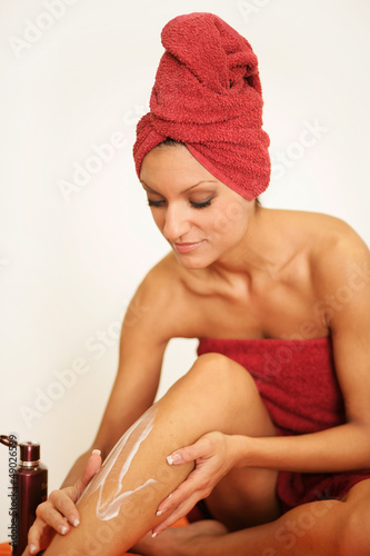 Photo: Frau cremt sich ein Frau cremt sich ein