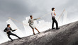 Three business people pulling rope