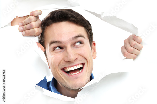Photo: Man peeping through hole on paper Man peeping through hole on paper