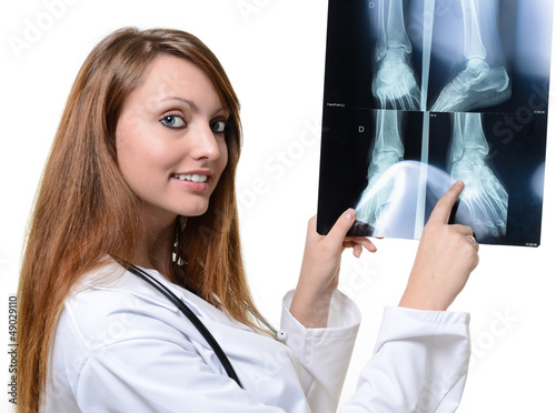 Photo: nice young female doctor looking at X-ray image nice young female doctor looking at X-ray image