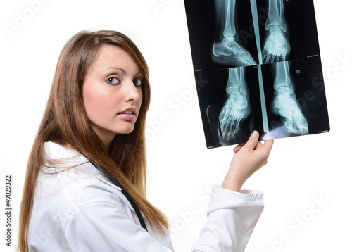 Photo: pretty female doctor looking at X-ray image pretty female doctor looking at X-ray image