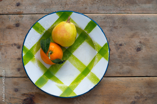Photo: fruits tangerine and pear in vintage porcelain dish plate fruits tangerine and pear in vintage porcelain dish plate