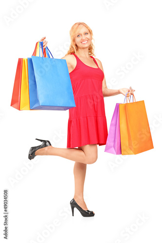 Photo: Full length portrait of a mature woman posing with shopping bags Full length portrait of a mature woman posing with shopping bags