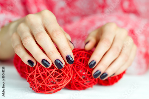 Photo: Hands with manicure touching decoration balls Hands with manicure touching decoration balls