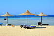 spiaggia di sabbia e  ombrelloni di paglia