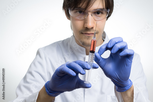 Photo: Wissenschaftler hält Spritze mit roter Flüssigkeit Wissenschaftler hält Spritze mit roter Flüssigkeit