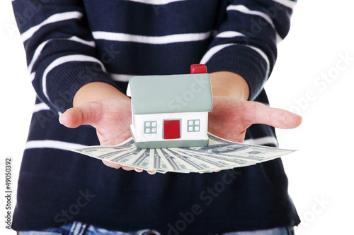 Photo: Woman holding US dollars bills and house Woman holding US dollars bills and house