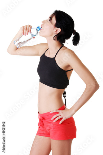 Photo: Young fit woman drinking mineral water Young fit woman drinking mineral water