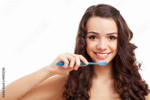 Photo: Young woman at home brushing teeth Young woman at home brushing teeth