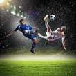 two football players striking the ball