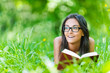 dark-haired young woman reading red book
