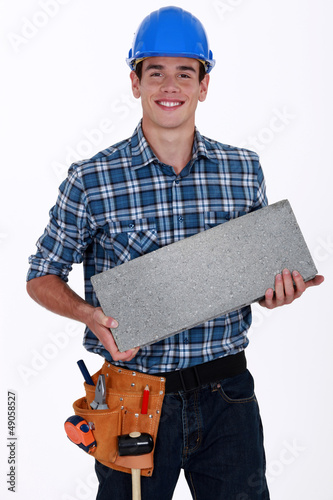 Photo: Builder with a concrete block Builder with a concrete block