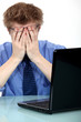 A stressed out man in front of his laptop