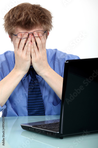 Photo: A stressed out man in front of his laptop A stressed out man in front of his laptop
