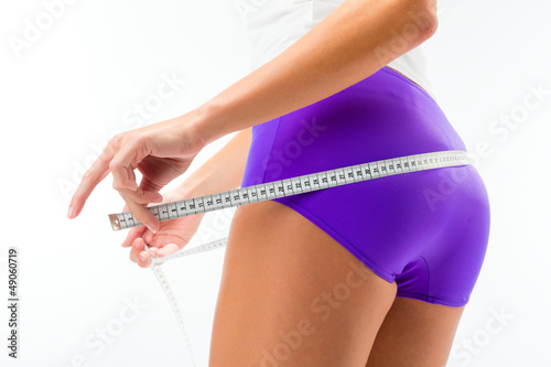 Photo: Woman measuring her hip with tape Woman measuring her hip with tape