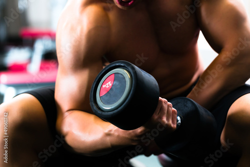 Photo: Man at Dumbbell training in gym Man at Dumbbell training in gym