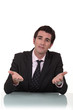 Businessman sitting at a desk talking to you