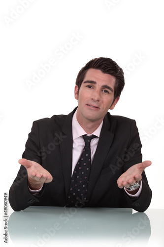 Photo: Businessman sitting at a desk talking to you Businessman sitting at a desk talking to you
