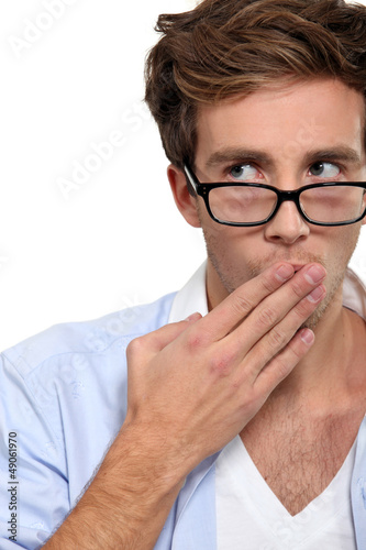 Photo: Man with his hand over his mouth. Man with his hand over his mouth.