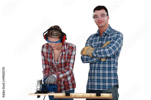 Photo: Couple using circular saw Couple using circular saw
