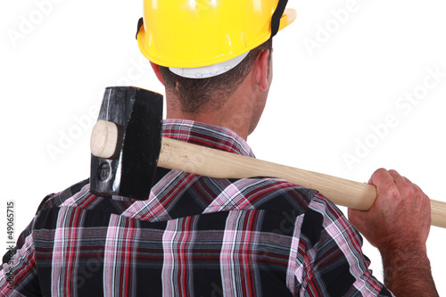 Photo: Worker resting large hammer over shoulder Worker resting large hammer over shoulder