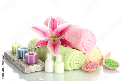 Photo: towels with lily, aroma oil, candles and sea salt isolated towels with lily, aroma oil, candles and sea salt isolated
