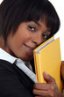 Businesswoman holding folder against face