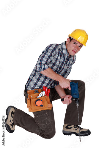 Photo: Man drilling into the floor Man drilling into the floor