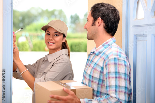 Photo: man receiving package from a delivery girl man receiving package from a delivery girl