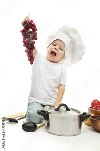 Photo: little girl in chef's hat with kitchen accessories ang grape, little girl in chef's hat with kitchen accessories ang grape,