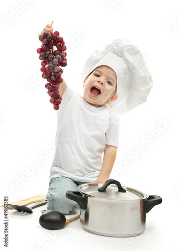 Photo: little girl in chef's hat with kitchen accessories ang grape, little girl in chef's hat with kitchen accessories ang grape,