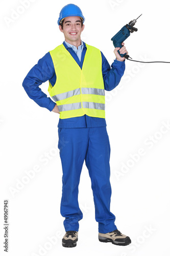 Photo: Cheerful builder holding drill Cheerful builder holding drill