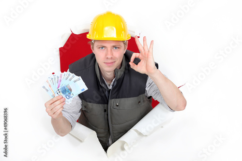 Photo: craftsman holding money and making an okay sign craftsman holding money and making an okay sign