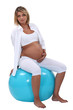 Pregnant woman holding her tummy and sitting on an ball