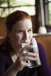 Young Woman with Beautiful Auburn Hair Drinking Water