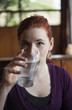 Young Woman with Beautiful Auburn Hair Drinking Water