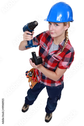 Photo: craftswoman putting a charger in a drill craftswoman putting a charger in a drill