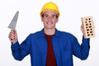 craftsman holding a brick and a trowel
