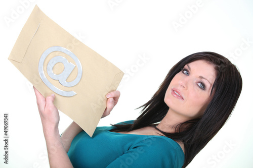 Photo: Woman holding an envelope with an at sign on it Woman holding an envelope with an at sign on it