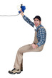 A handyman holding a speaker.