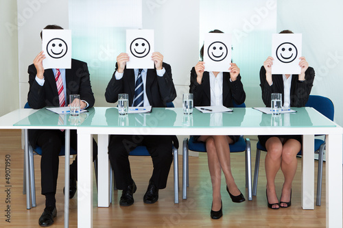 Photo: Row of business executives with smiley faces Row of business executives with smiley faces