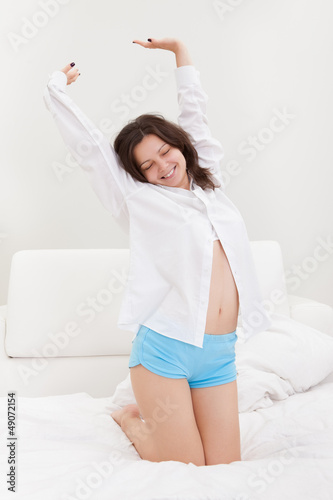 Photo: Young woman stretching after waking up Young woman stretching after waking up