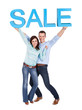 Happy young couple holding sale sign