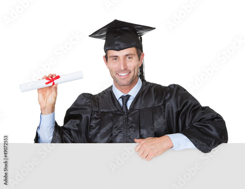 Photo: Happy graduate student presenting empty banner Happy graduate student presenting empty banner