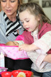 Mother watching little girl play with toy doll