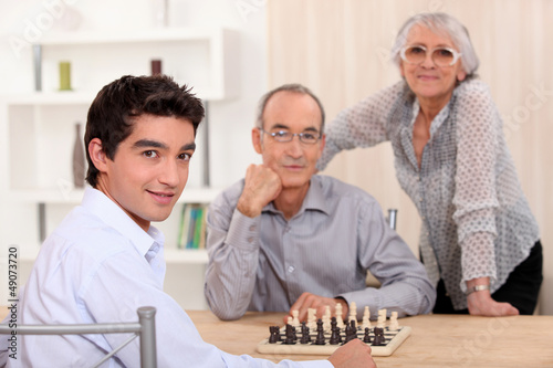 Photo: Family playing chess together Family playing chess together