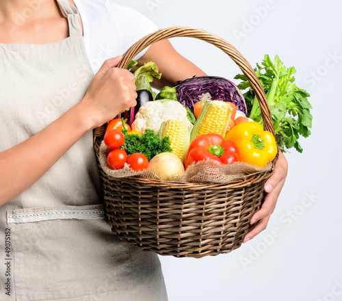 Photo: Smiling woman with fresh produce basket full of vegetables Smiling woman with fresh produce basket full of vegetables