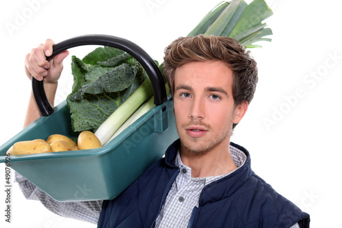 Photo: young farmer with a vegetables basket young farmer with a vegetables basket